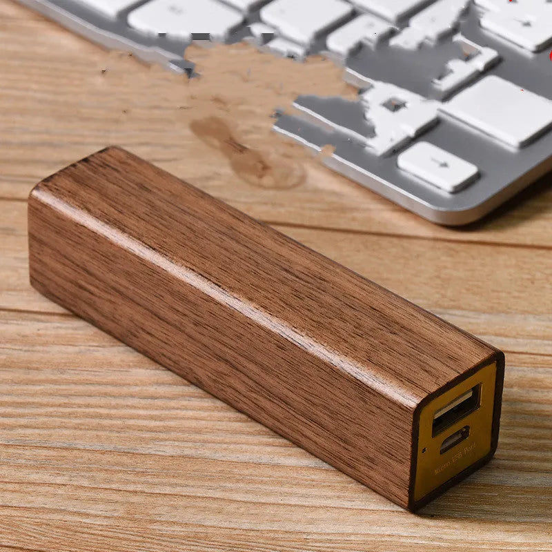 Portable power bank with brown walnut wood shell showing charging ports