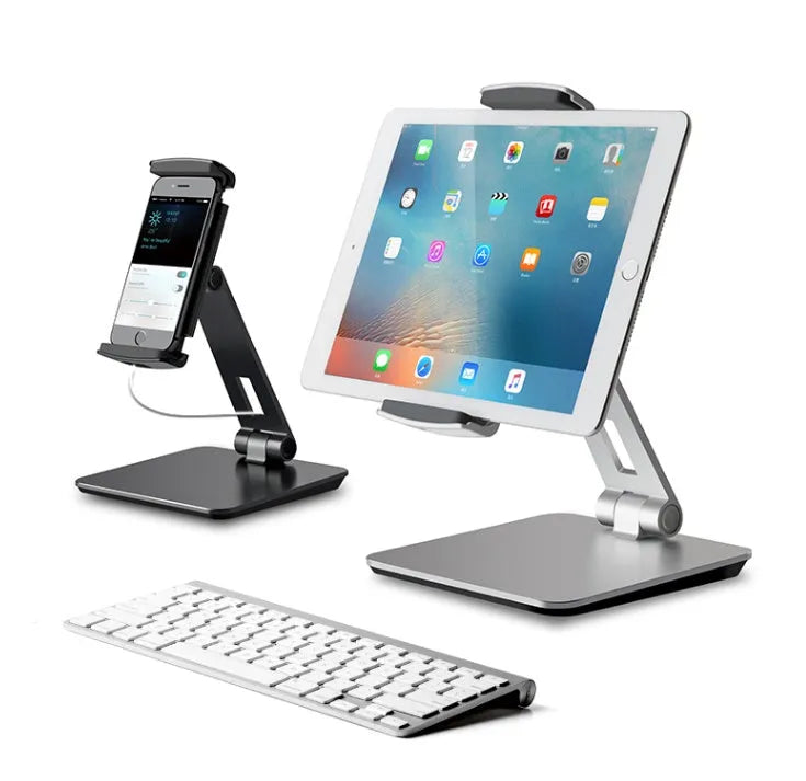 Silver aluminium folding phone and tablet stand on a desk, holding a tablet