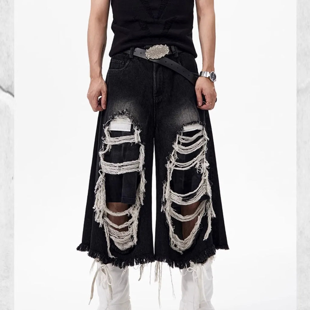 Black wide-leg cropped jeans with ripped patch details on a mid-high waist, loose fit.