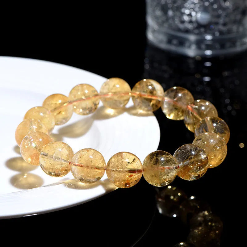 Natural yellow citrine gemstone bracelet with geometric beads on white background