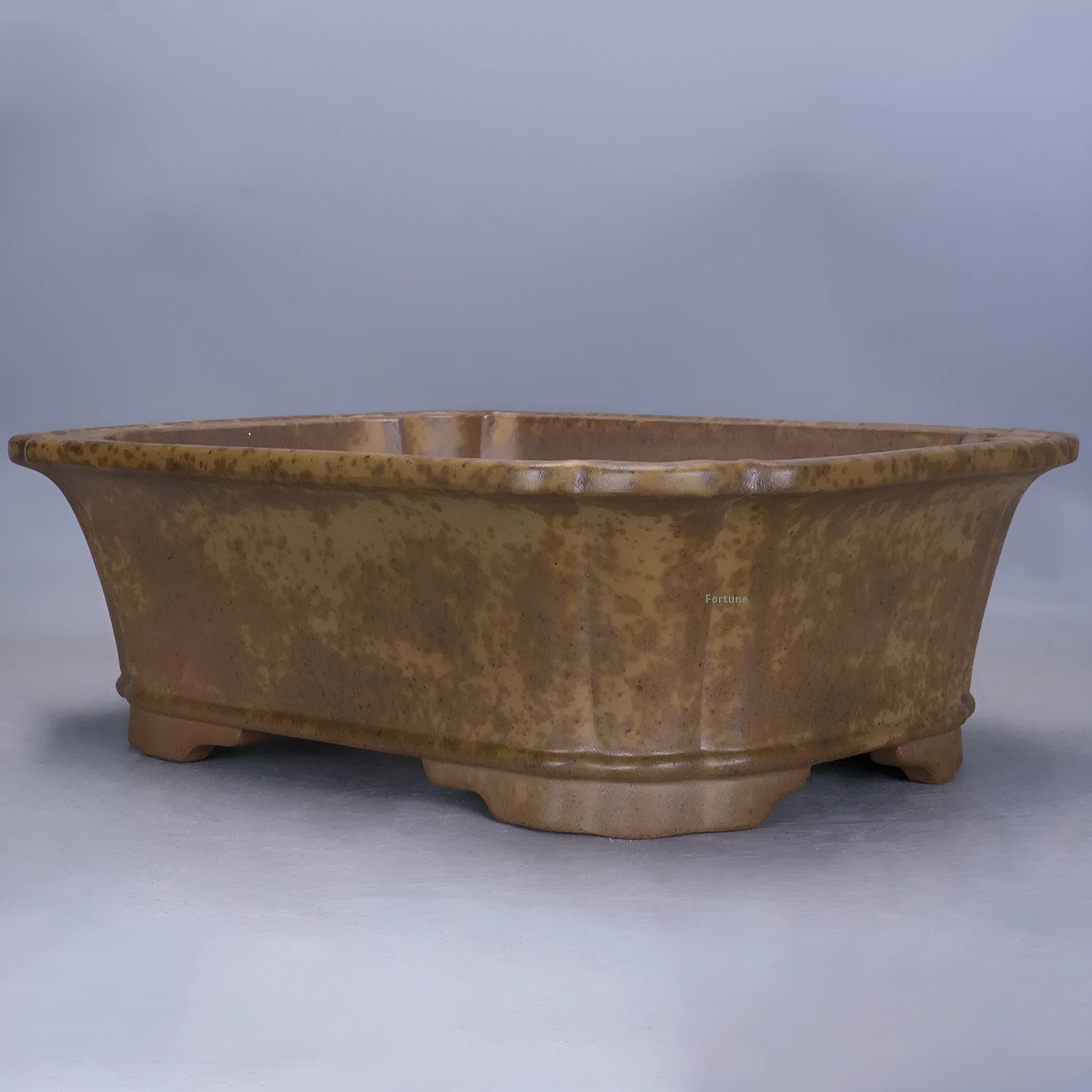 A large rectangular purple sand mud flowerpot with angled segment design on a floor.