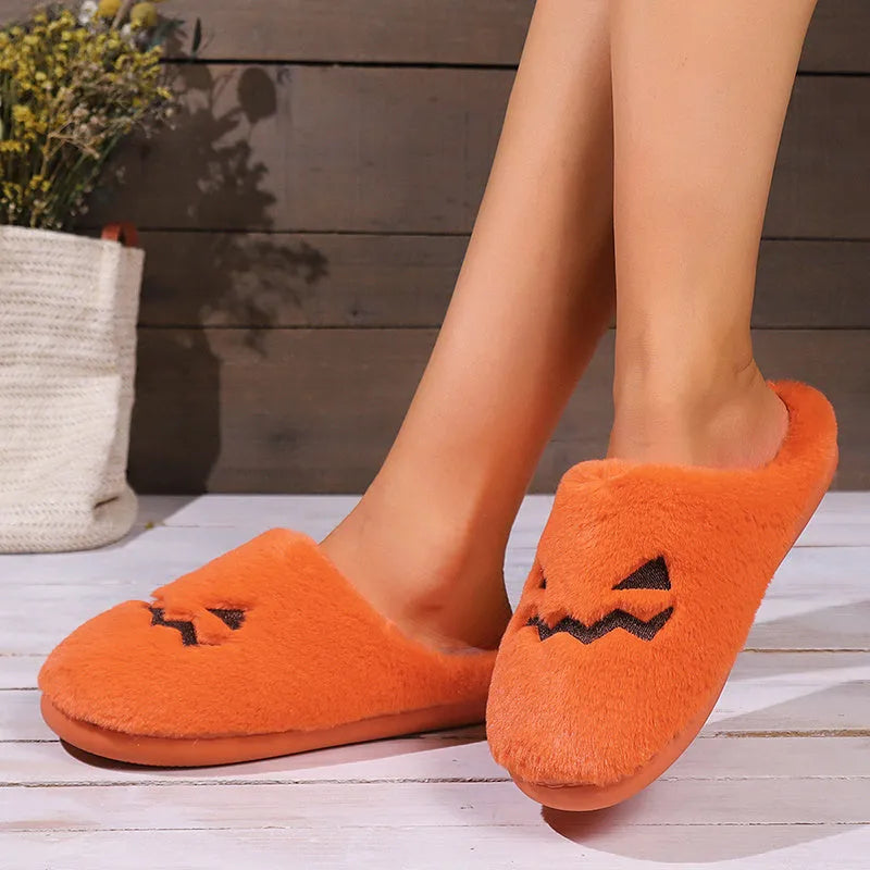 Orange plush Halloween pumpkin slippers with coral velvet upper and flat PVC sole.