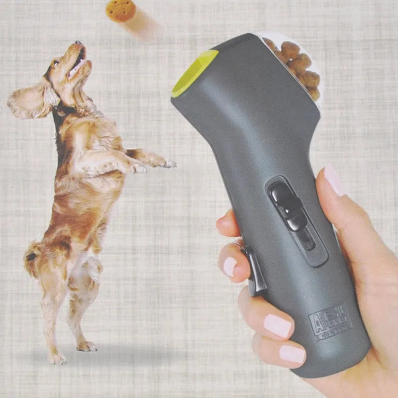 Grey compact pet snack catapult launcher on a plain background, showing the handle and trigger mechanism.