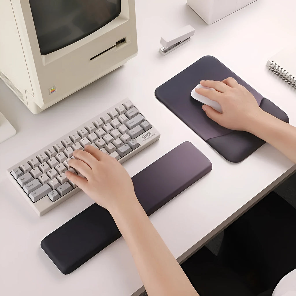 Square black silica gel wrist rest mouse pad with cloth surface on a desk.