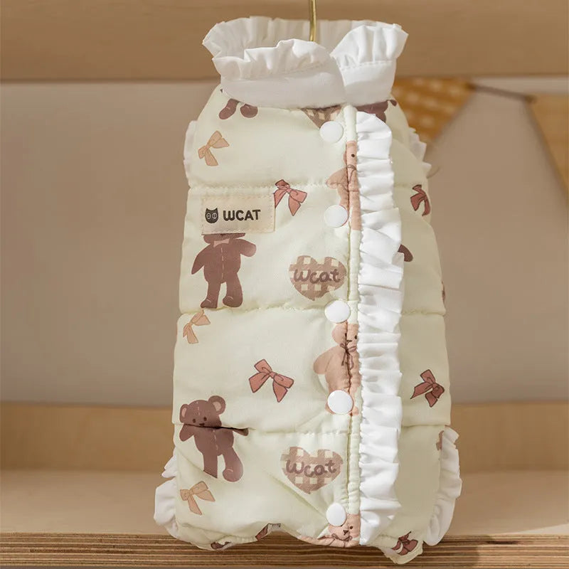 Small dog wearing cream fleece jumpsuit with bear pattern and white ruffles