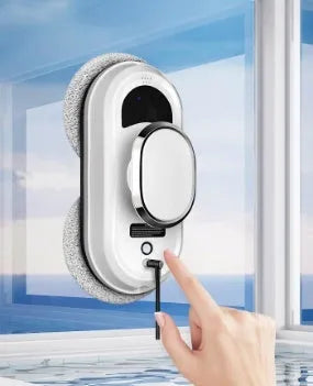 White full-automatic high-altitude window cleaning machine with remote control on a windowsill.