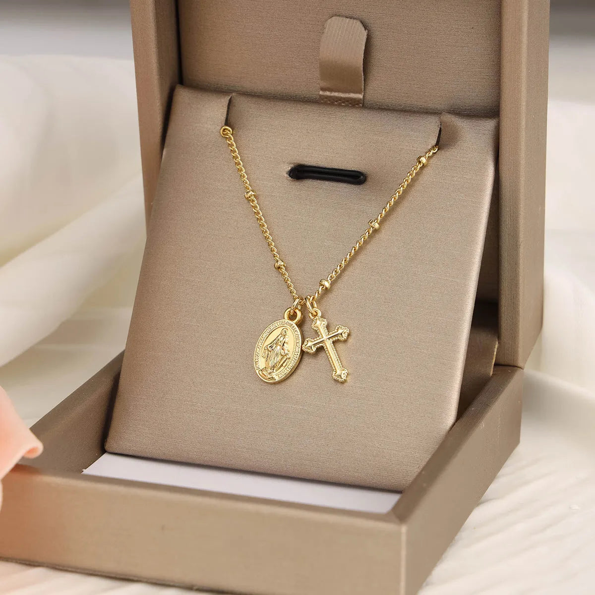 Gold geometric Virgin Mary cross necklace on a chain, simple style.