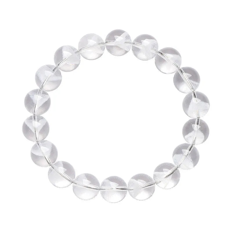 Women's white crystal pyramid bracelet with Ruyi symbols on wrist, showing ground bead texture.