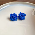 Women's geometric cloth earrings with blue resin flower detail and Silver Needle colour