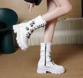 Black mid-calf women's boots with a large metal buckle and side zip on a white background.