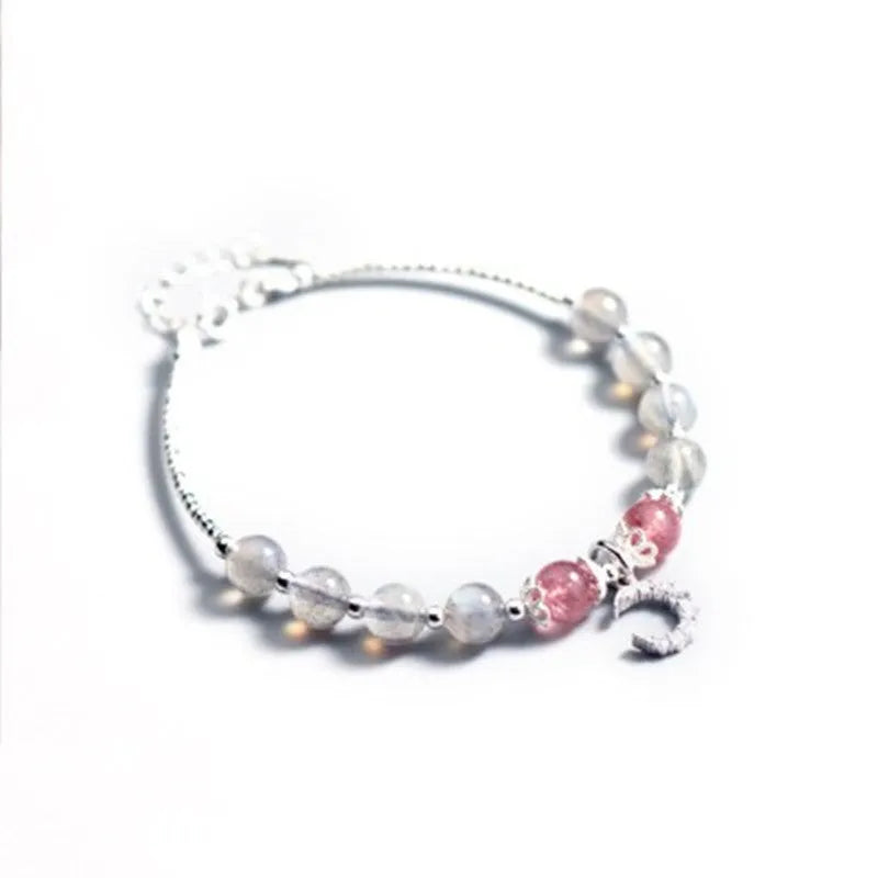 Handmade adjustable moonstone bracelet with crescent moon charm and crystal pendant on wrist