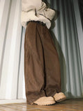 Men's pleated straight-leg loose trousers in apricot colour showing front detail and micro-elastic waistband.