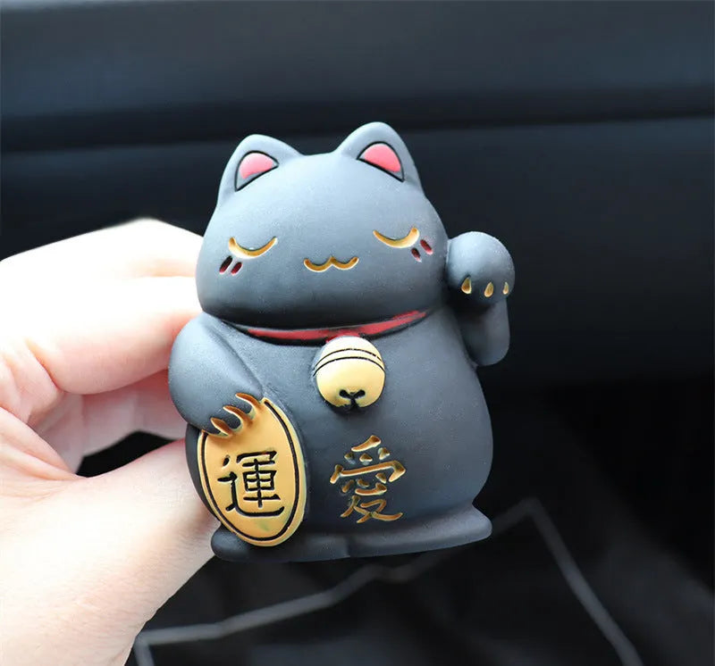 Black and white cat resin aromatherapy clip attached to a car air conditioning vent.