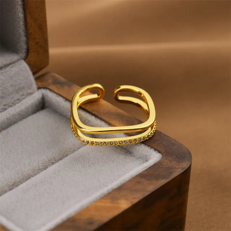Gold geometric open copper ring with electroplated finish, adjustable for different finger sizes.