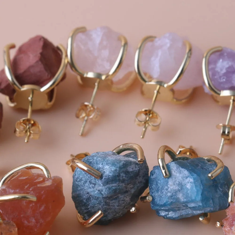 Rough stone crystal earrings with gold plated four claws on a black background