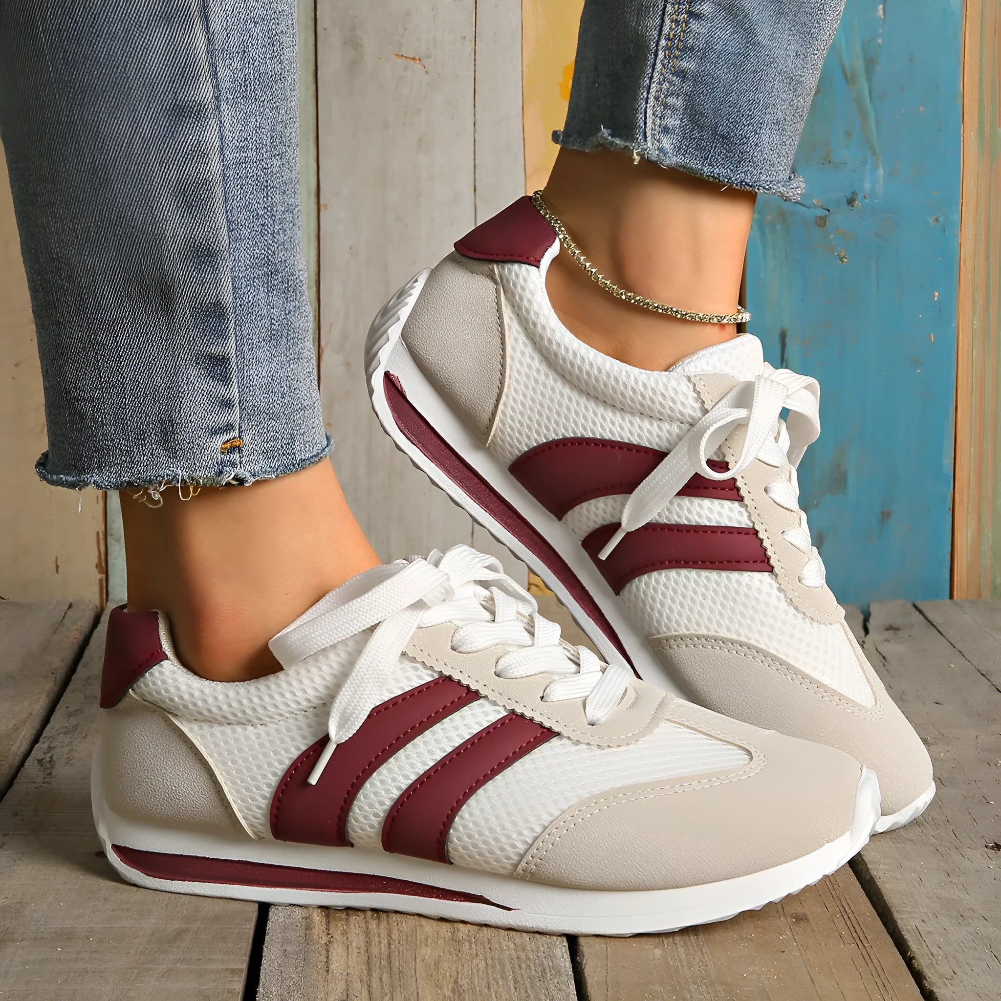 Wine red Cortez Retro sneaker with mesh upper, cross strap, and flat rubber sole.