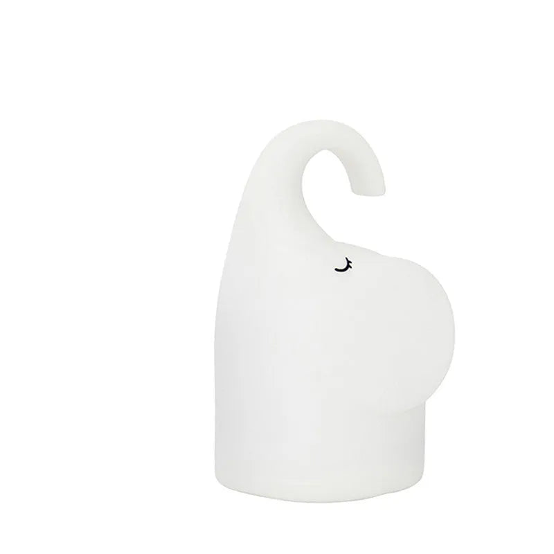 DOMI Elephant-shaped silicone USB night light with warm white glow on a bedside table.