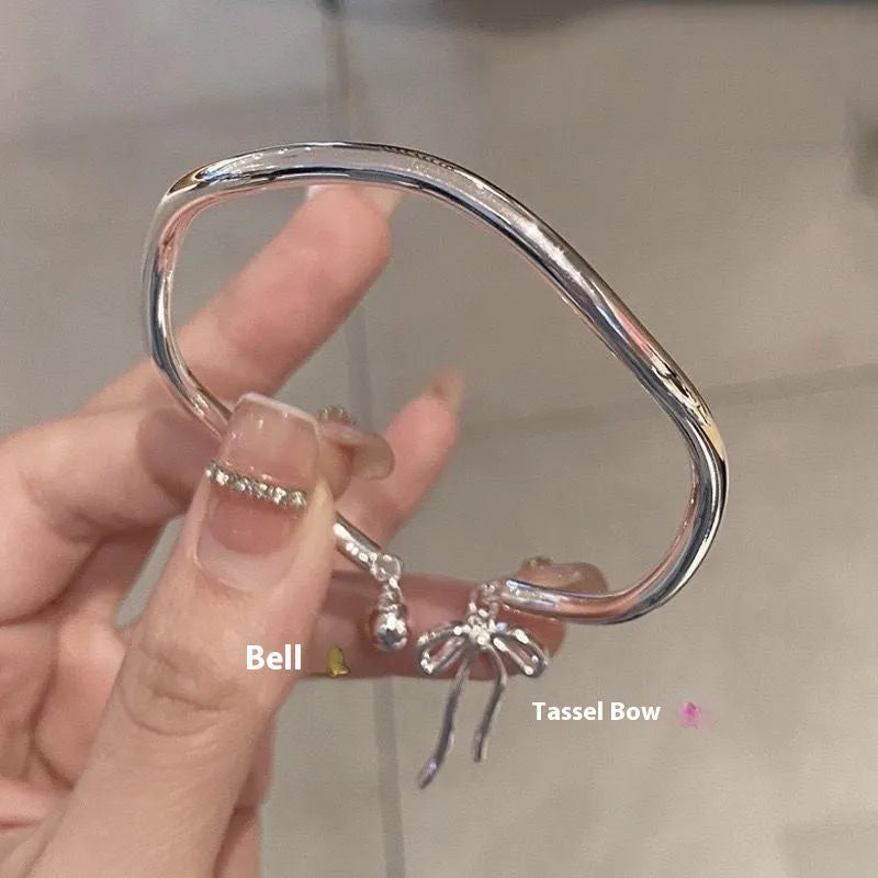 Silver adjustable bracelet with bow charm and bell opening mechanism