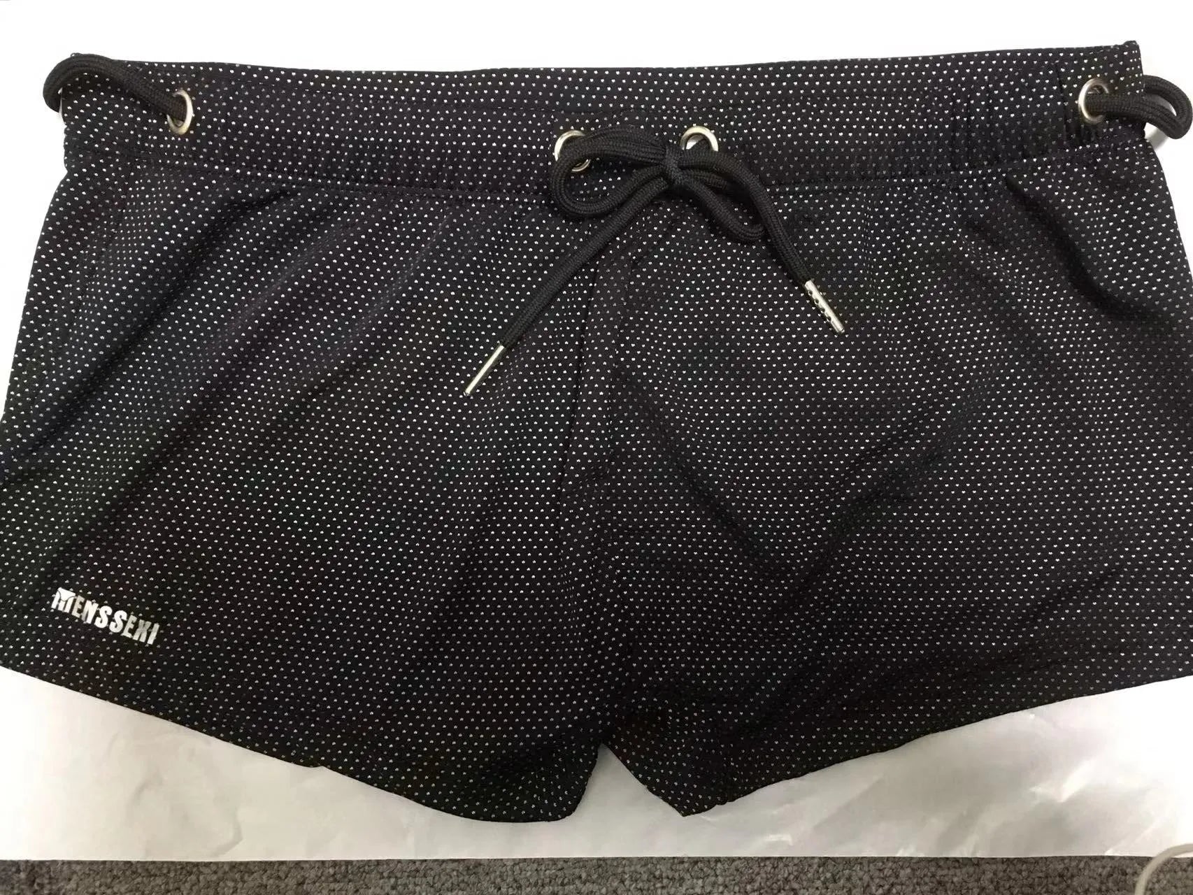 Men's solid colour lace nylon low waist boxer swimming trunks on a white background.