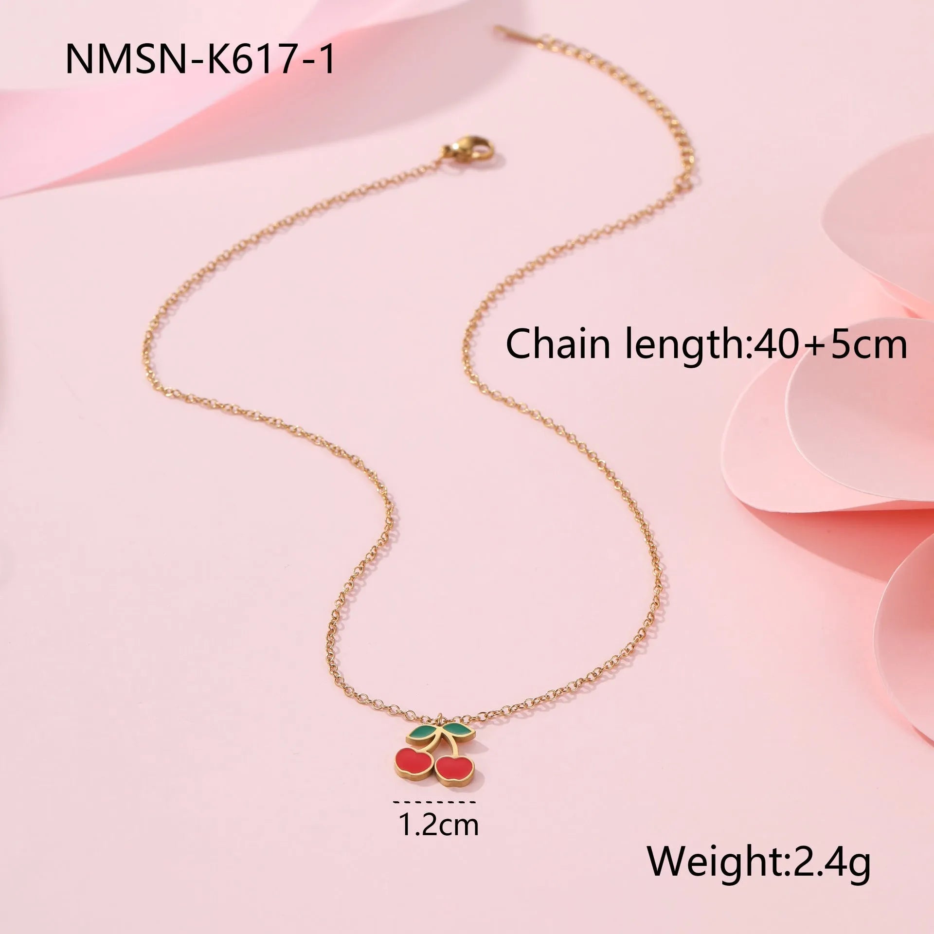 Cherry design jewellery set with gold plated necklace, bracelet, earrings, and ring on a flat surface.