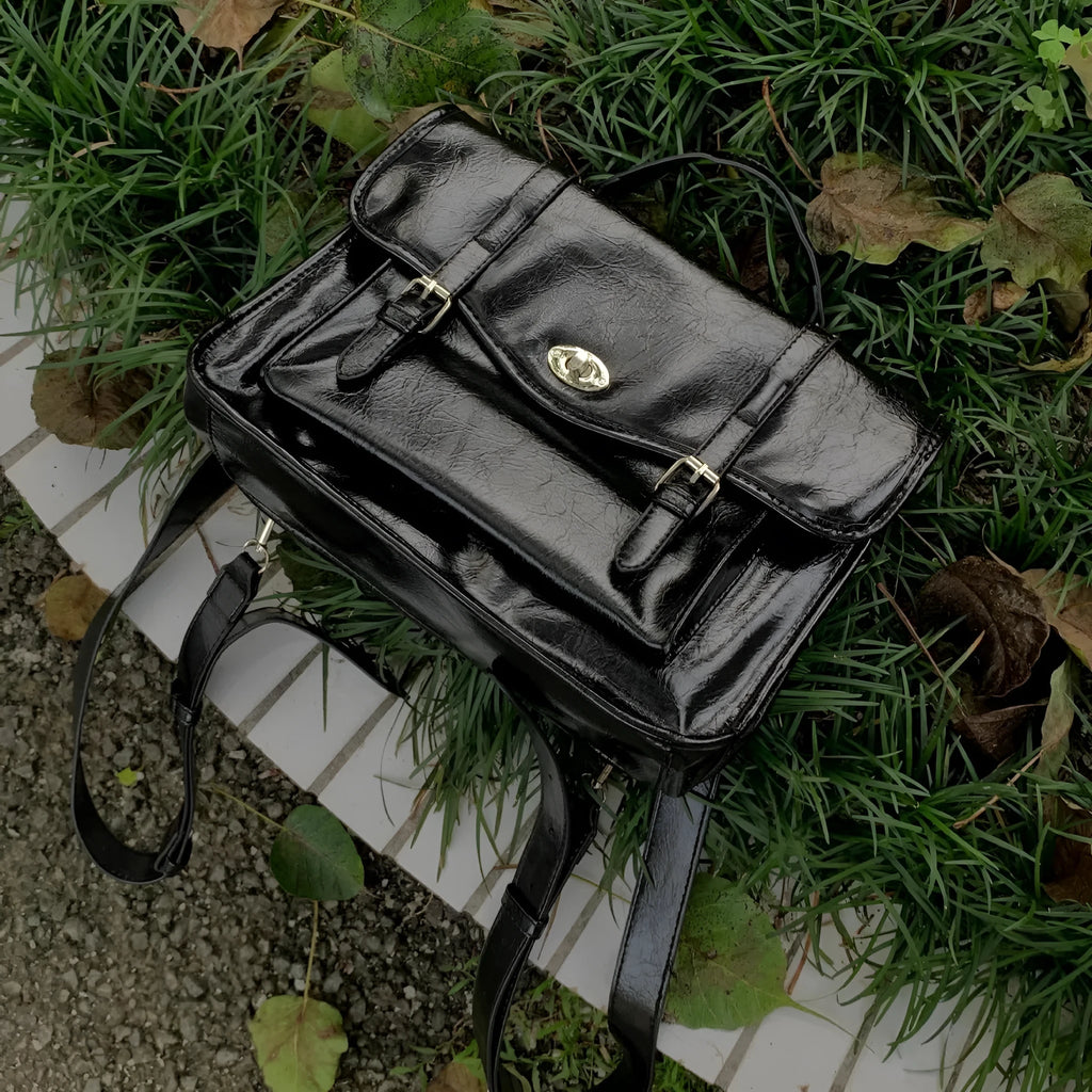 Black college style messenger bag with oil wax leather finish and 35cm length dimensions