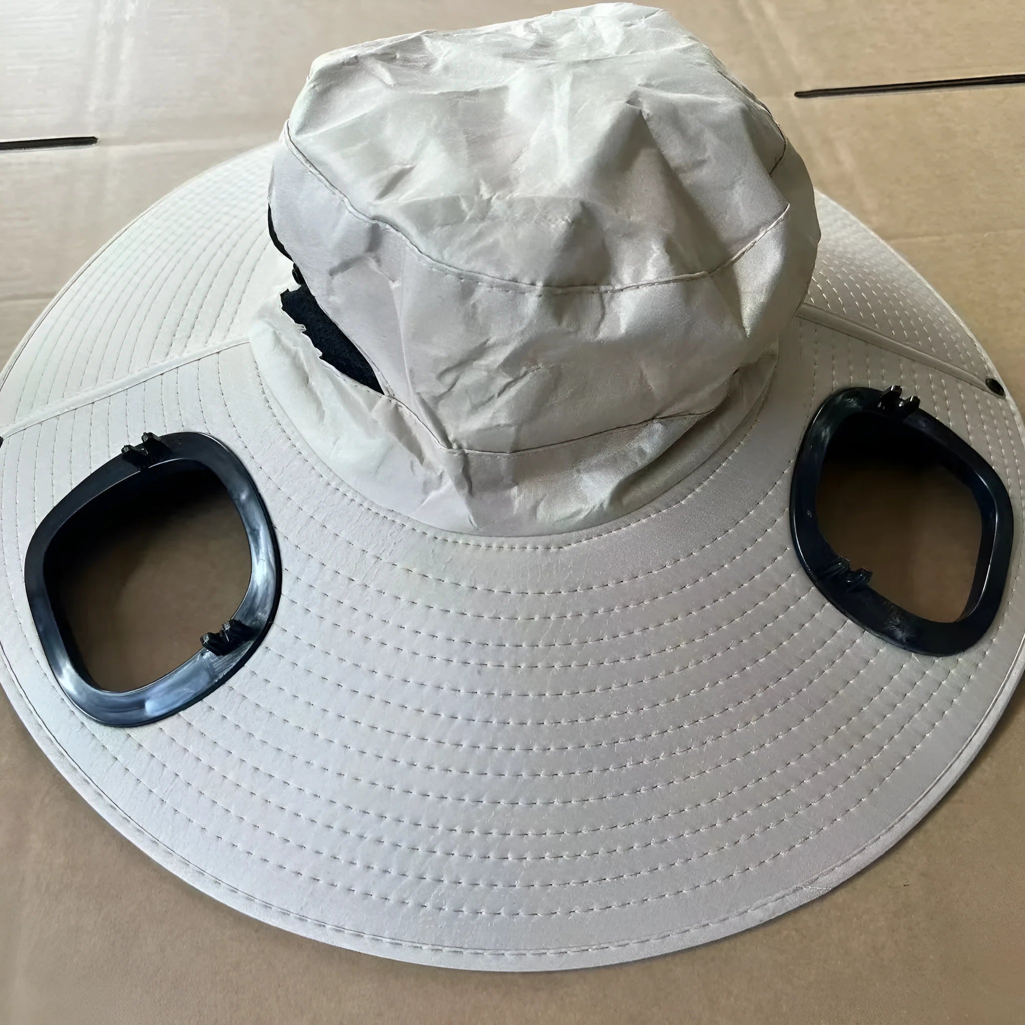Men's grey solar-powered cooling cap with large brim and a detachable black ABS fan unit on the front.