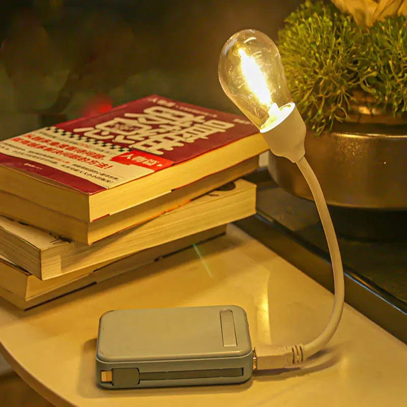 USB rechargeable folding night light with warm tungsten bulb illuminated.