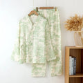 Women's pink cotton gauze lounge suit set with lace-up long sleeve top and matching trousers on a hanger.