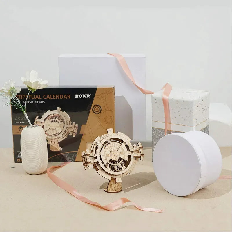 Flat-packed wooden 3D puzzle film projector with visible gear wheel assembly and hand crank