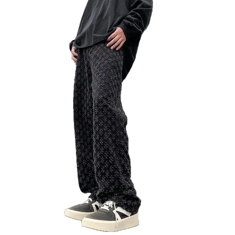 Men's black jacquard full-print denim jeans with button fly, laid flat showing all-over pattern