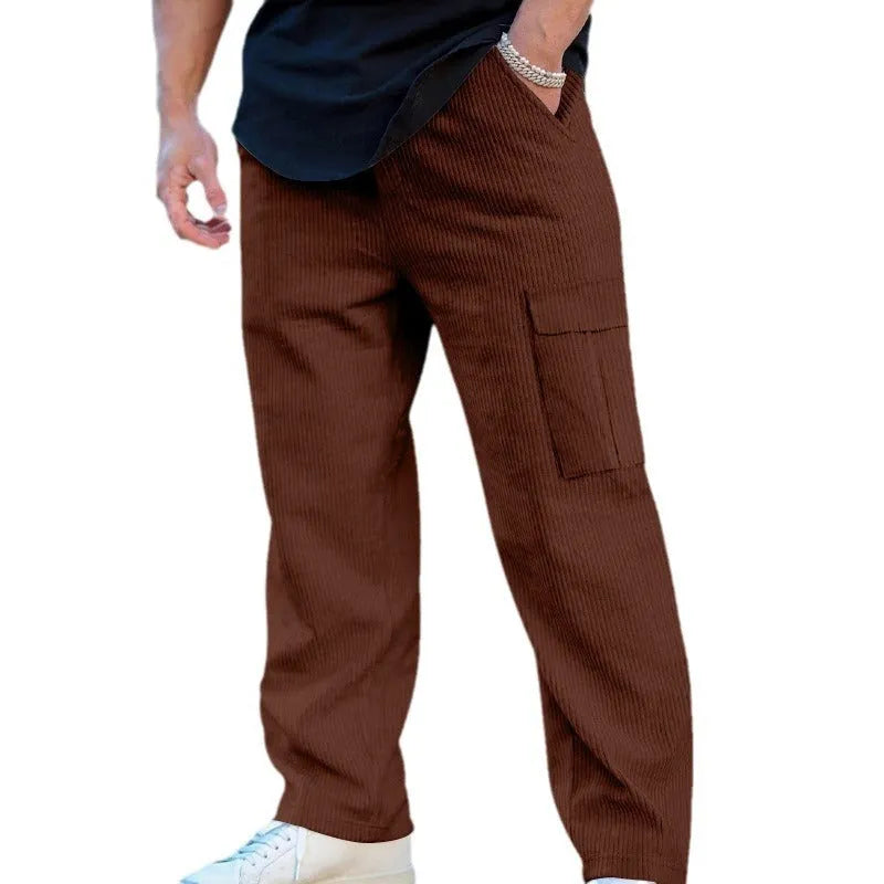Man wearing loose-fitting straight-leg corduroy cargo trousers in navy blue with a drawstring waist.