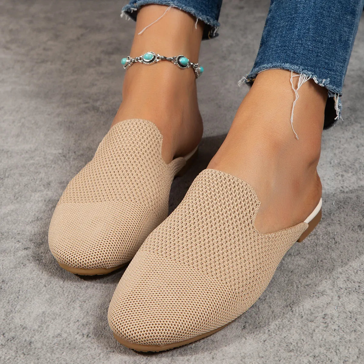 Apricot coloured mesh slip-on sandals with round toe, cloth upper, and flat rubber sole.