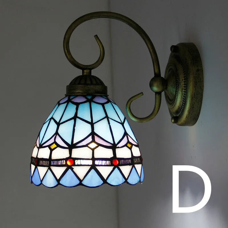 A coloured stained glass wall lamp mounted on a corridor wall, showing one of six available style variants.