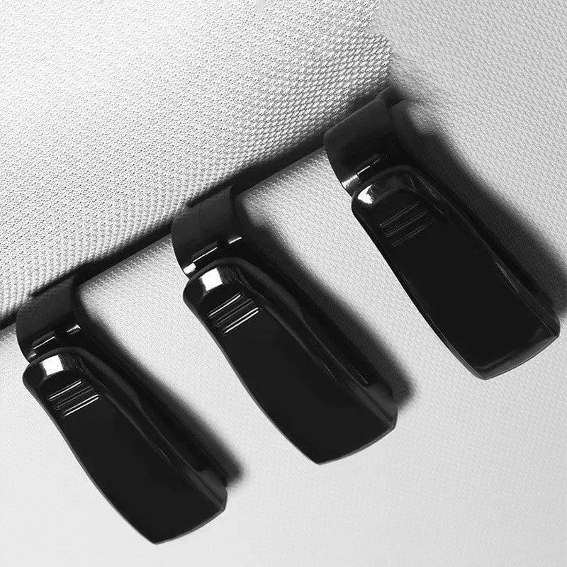 Black plastic clip for car sunshade to hold sunglasses and cards, dimensions 6.5 by 2.3 cm.