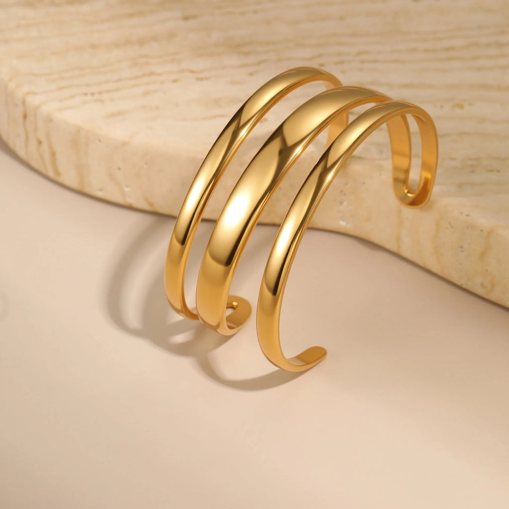 Women's stainless steel simple opening bracelet with geometric line design in gold or steel colour.