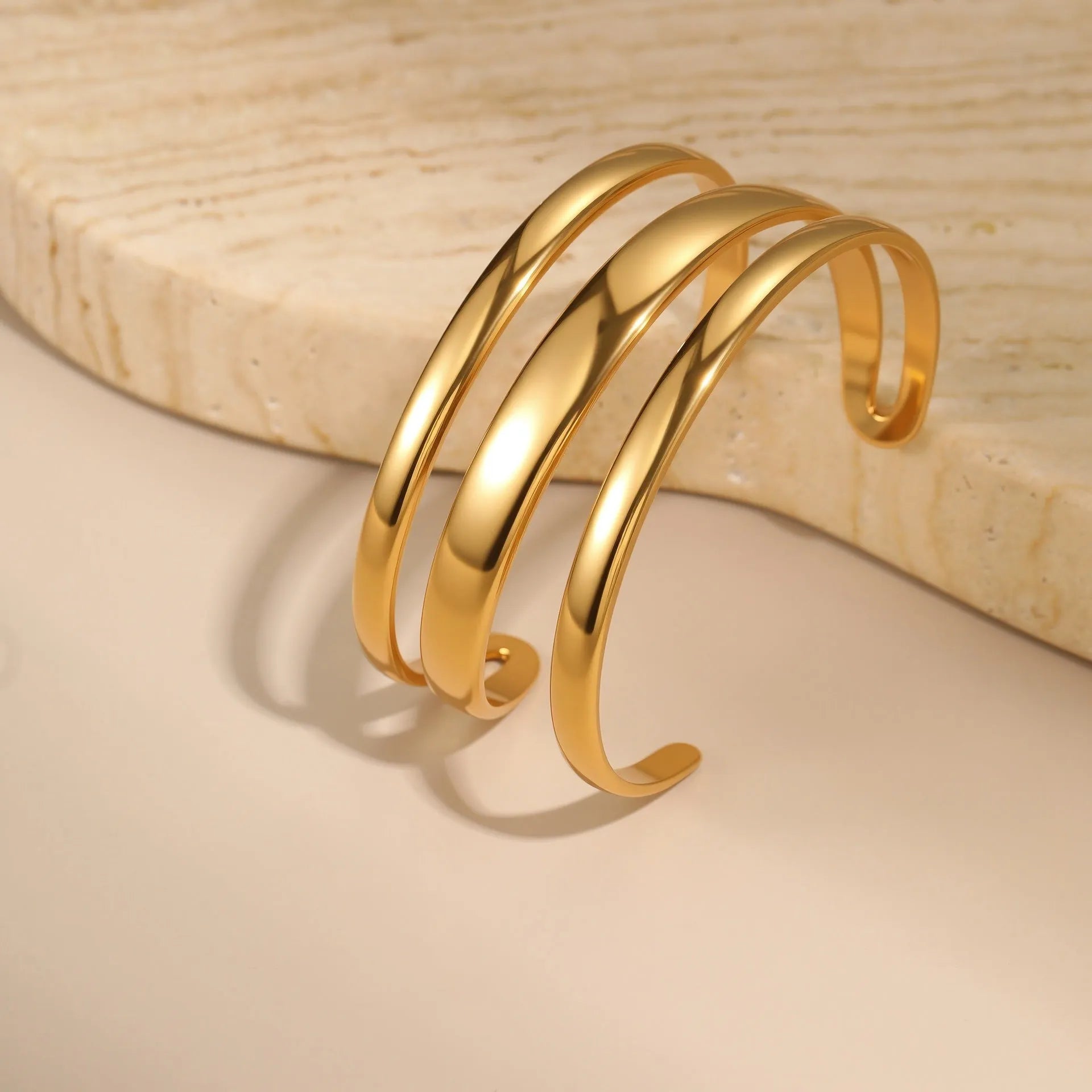 Women's stainless steel simple opening bracelet with geometric line design in gold or steel colour.