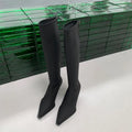 Black women's below-the-knee boots with pointed toe, stiletto heel, and a back zipper.