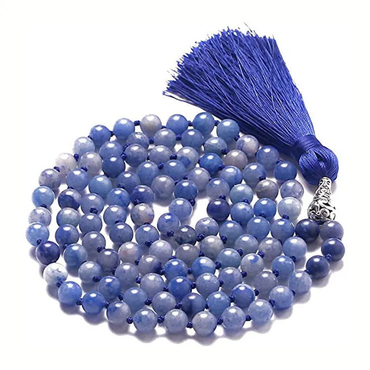 Long beaded agate and amethyst tassel necklace with geometric pendant on a neutral background.