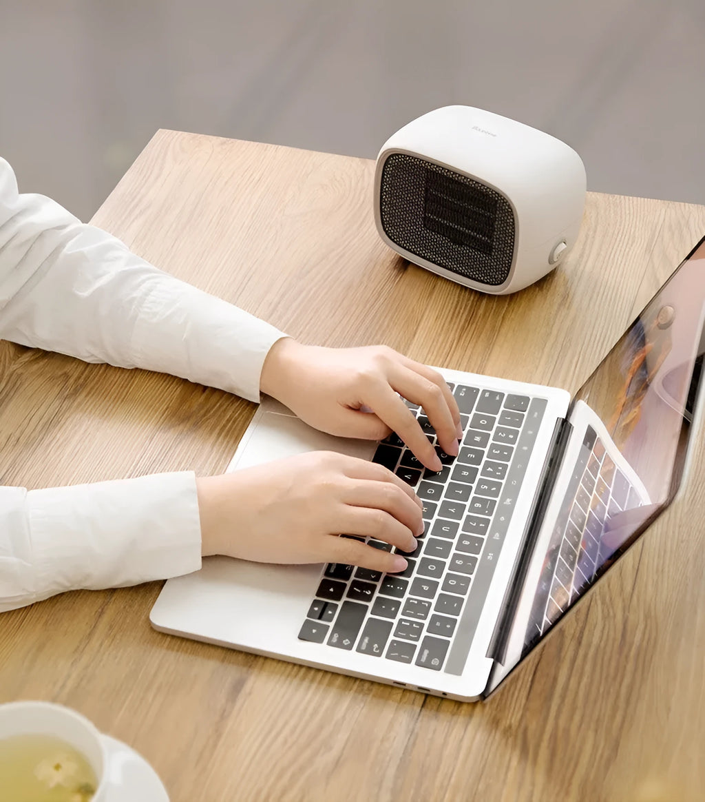 Green mini ceramic space heater with EU plug on a wooden desk