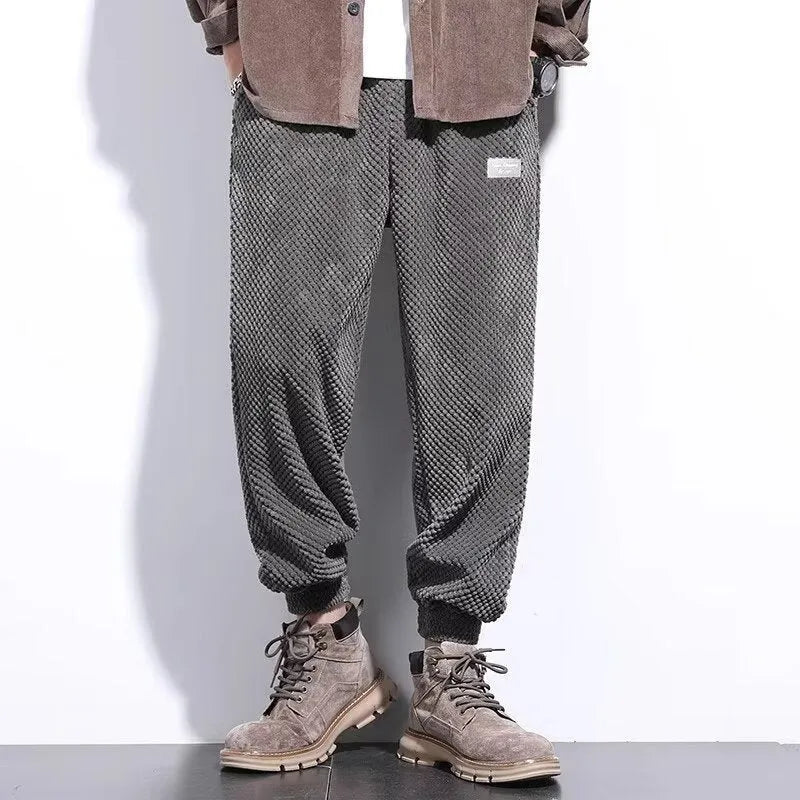Men's grey ankle-tie sweatpants with a straight leg on a plain background