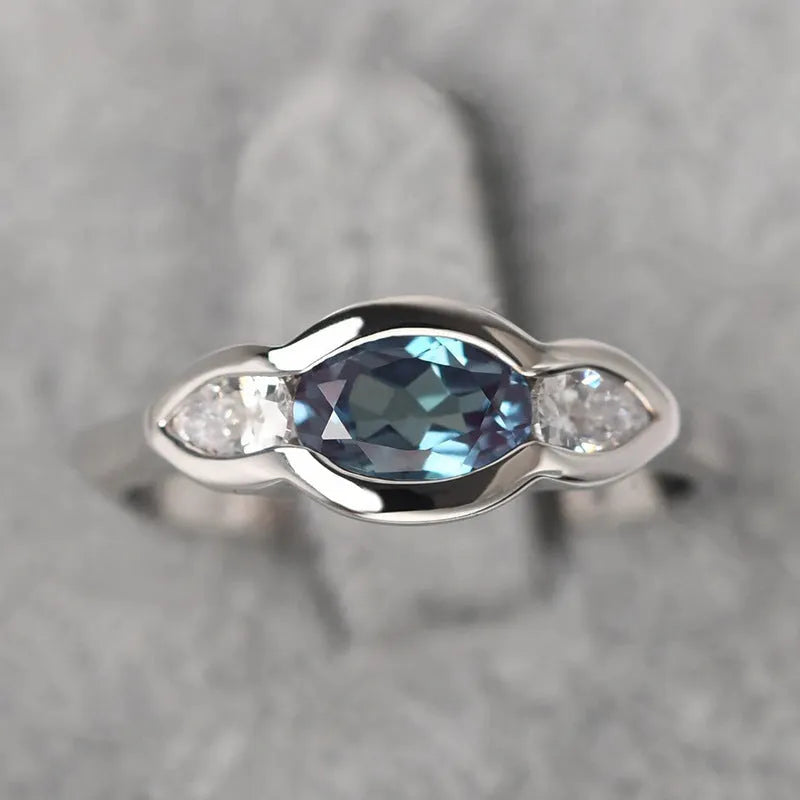 Women's geometric ellipse ring with inlaid zircon stone in white gold colour, shown on a hand.