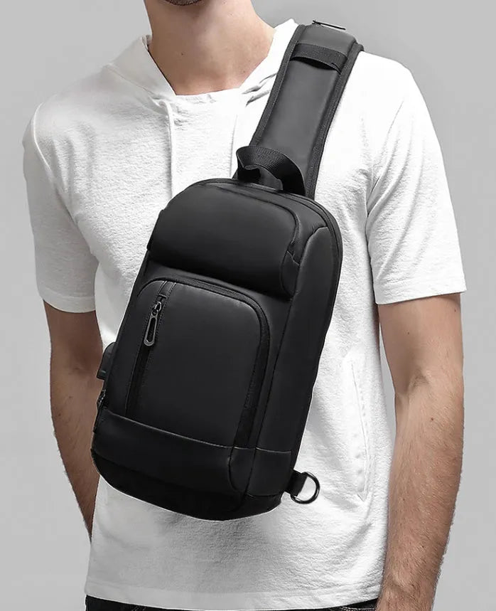 Black PVC medium-sized shoulder bag with air cushion strap and soft handle.