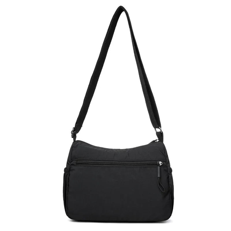 Water-repellent nylon crossbody cloth bag showing internal zipper compartments and shoulder strap