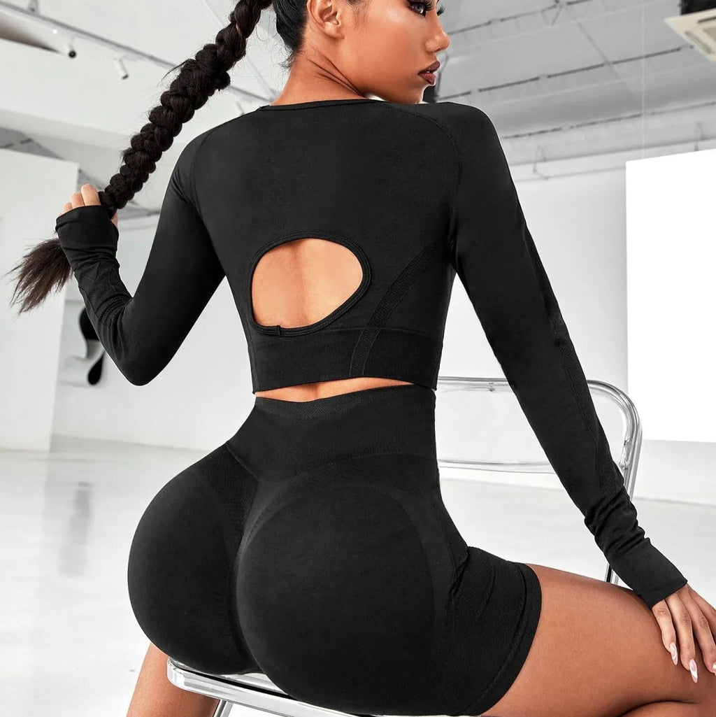 Women's black yoga suit set with long sleeve top and high-waist tight leggings laid flat.
