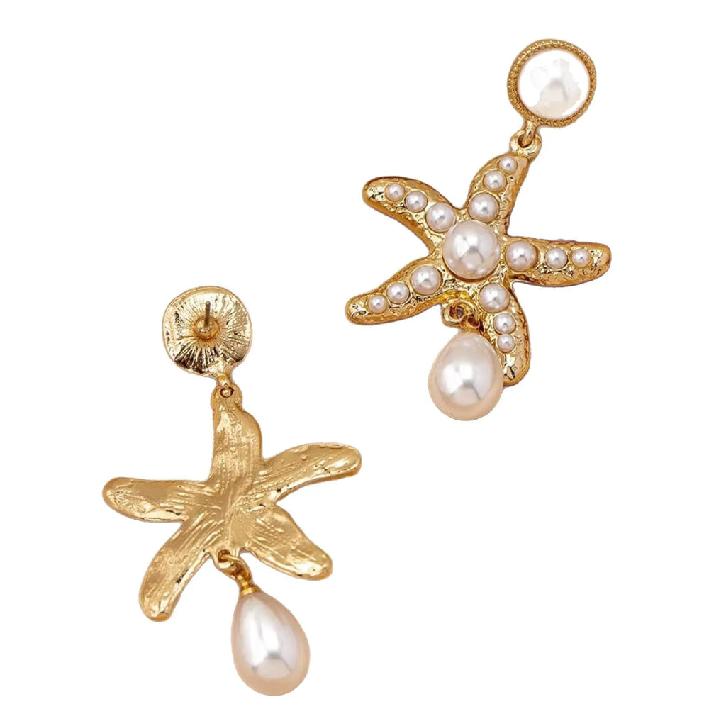 Women's gold-tone starfish drop earrings with a single off-white pearl centre on a light background