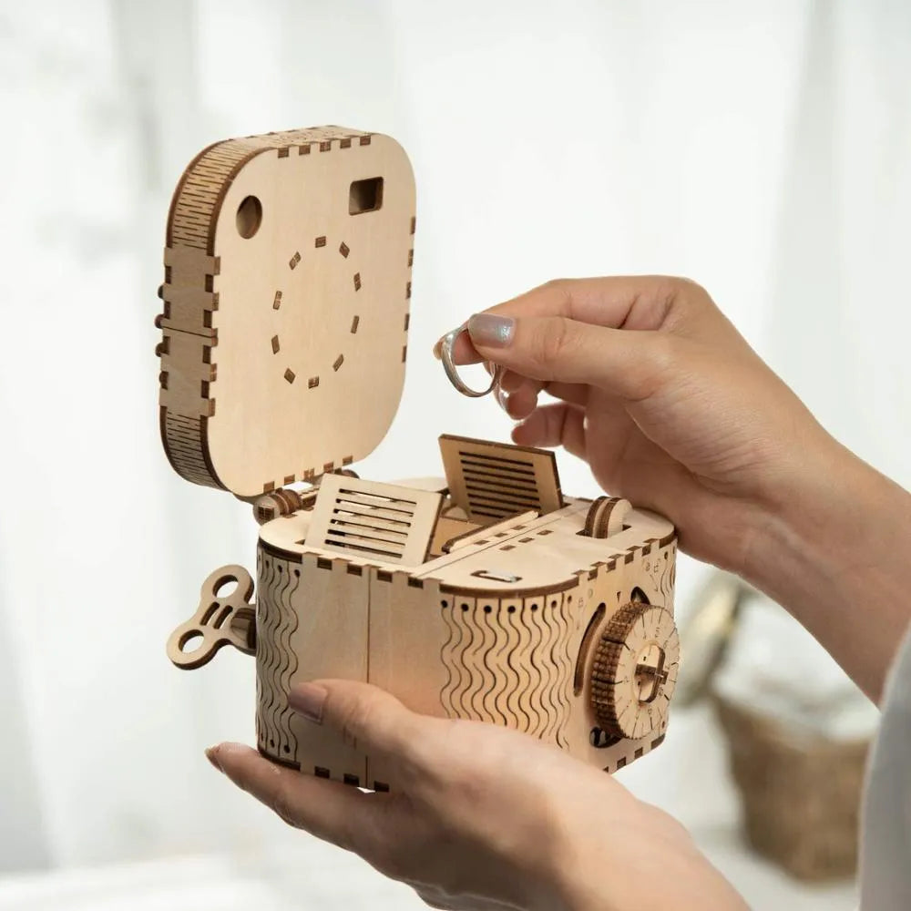 Flat-packed wooden 3D puzzle film projector with visible gear wheel assembly and hand crank