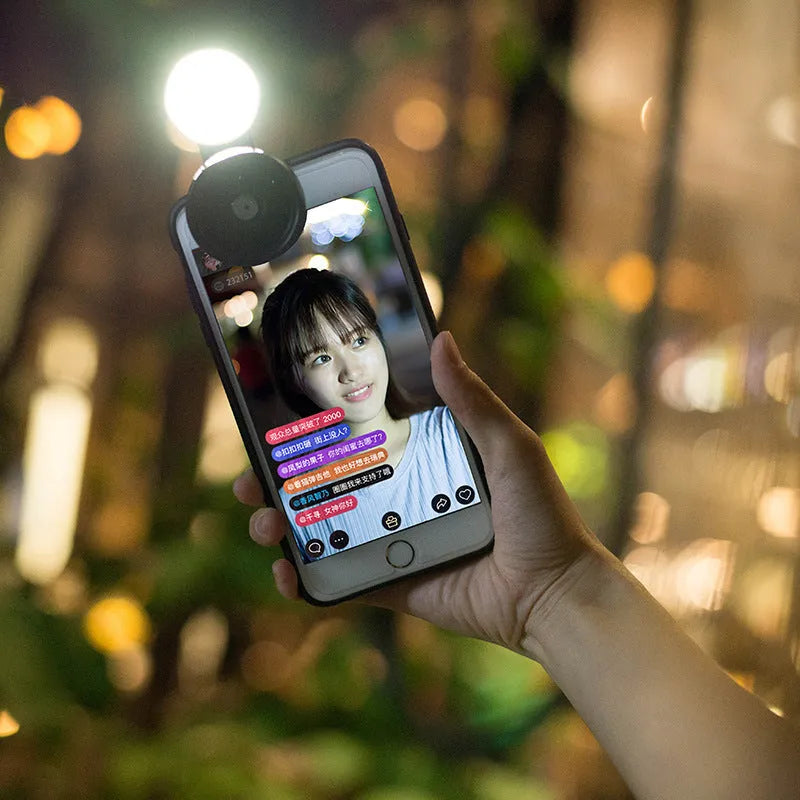 Smartphone wide-angle camera lens and colourful LED selfie light kit in black, red, and silver grey.
