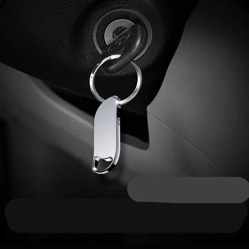Metal keychain digital voice recorder in black on plain background showing USB port and controls