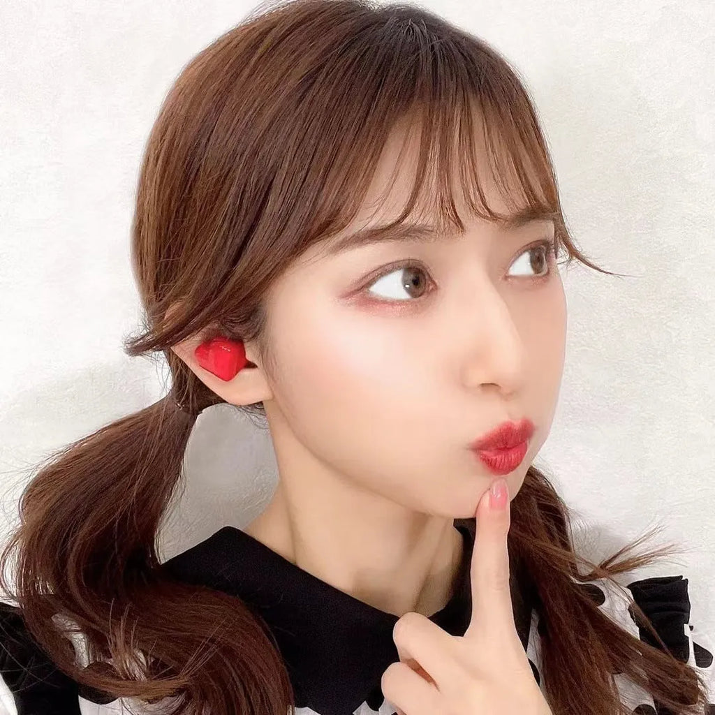 Heart-shaped wireless Bluetooth earphones in red and pink colours with charging cable