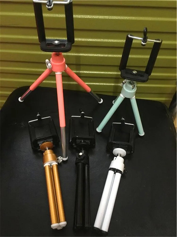 Black aluminium alloy desktop phone holder with an adjustable two-section bracket holding a smartphone.